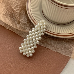 Detail of vintage rectangular pearl hair clip on a retro background with soft lighting