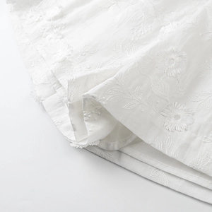 Close-up of white 3D flower embroidery and high-quality cotton linen fabric detail
