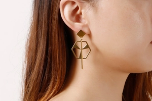 Macro shot of long gold geometric earrings featuring a hexagon hollow frame on a model