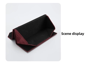 Macro shot of triangular folding glasses case showing burgundy suede and black lining