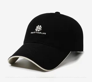 Macro view of black cotton baseball cap showing white embroidery and contrast brim detail