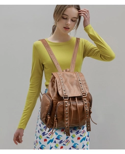 Close-up of brown washed leather backpack with silver studs on a female model