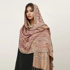 Detail shot of wine red paisley cashmere-like scarf showing intricate fringe and texture