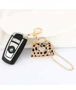 Leopard print handbag keychain with sparkling rhinestones and golden metal hardware details