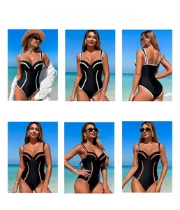 Detail view of one-piece swimsuit with contrast piping and open back on a sunny beach