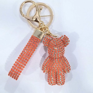 Detail of orange crystal bear keychain with matching rhinestone strap and golden metal ring