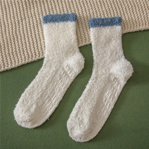 Detail of white fluffy coral fleece slipper socks with non-slip grippers on the sole