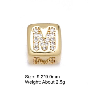 Macro shot of 8mm gold letter M charm with pavé cubic zirconia for DIY jewelry