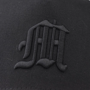 Close-up of a black cotton baseball cap featuring 3D embossed letter embroidery