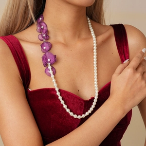 Detail of elegant long pearl necklace featuring handmade purple chiffon flower accents