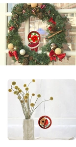 Red poinsettia and cardinal bird Christmas ornament hanging on a festive green wreath