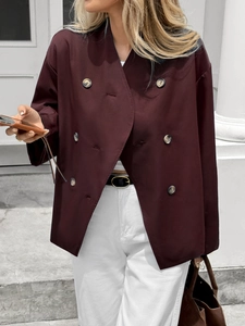 Detail of a dark reddish-brown double-breasted coat featuring elegant buttons