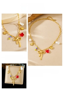 Detailed close-up of a gold-plated bow necklace with red resin butterfly and pearl charms