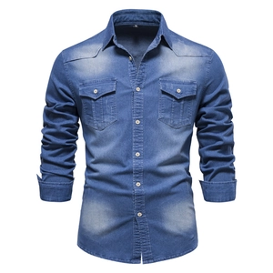Detail of blue denim shirt showing front flap pockets and white button closure