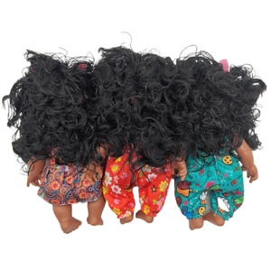 Rear view of three black baby dolls featuring dense curly hair and patterned jumpsuits