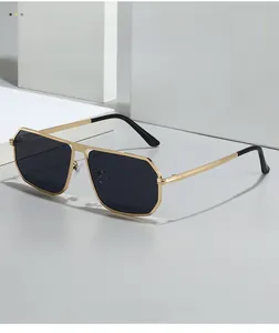 Detail of pilot sunglasses with gold metal double bridge and dark black lenses
