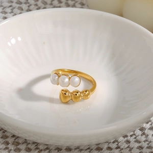 Detailed close-up of a gold pearl ring on a ceramic bowl with minimalist design