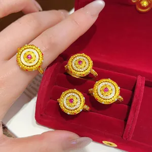 Détails d'une bague vintage en or avec pierre rouge et motifs filigranes complexes