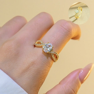 Detail of gold bow ring featuring an oval zircon stone and micro-pave accents