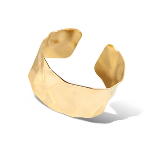 Irregular wide hammered gold cuff bracelet in titanium steel with a polished finish