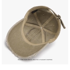Detail view of khaki distressed cotton baseball cap with vintage worn-out brim and metal buckle