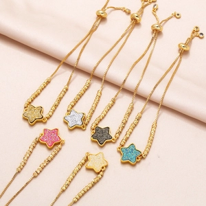 Adjustable gold star bracelets with colorful glitter pendants on pink silk background