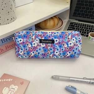 Detailed top view of a blue floral canvas pencil case on a clean white student desk