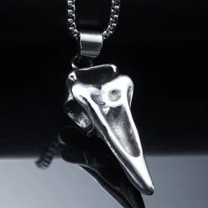Macro shot of silver bird skull pendant in stainless steel with polished box chain link