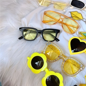 Collection of colorful retro flower and heart shaped daisy sunglasses on white fur