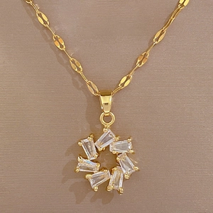 Detailed close-up of a gold titanium necklace featuring a floral pendant with sparkling stones