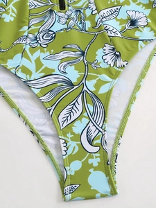 Detail of green tropical leaf pattern and black metal zipper on bikini swimwear