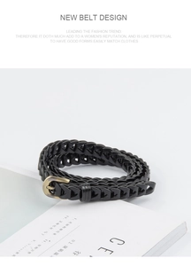 Detail view of woven vintage belt with arrow pattern and bronze buckle on white background