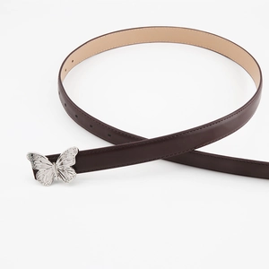 Detail of retro dark brown leather belt with ornate silver butterfly metal buckle