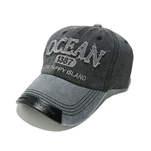 Detailed view of OCEAN embroidery and leather patchwork brim on vintage baseball cap