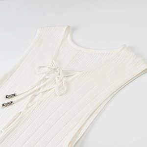Detail view of white ribbed knit sleeveless top featuring front lace-up metal aglets