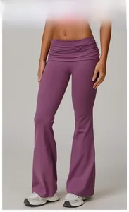 Detailed view of high-waisted flared yoga pants in plum purple with pleated waist details