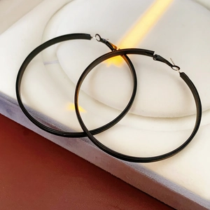 Détails de grandes boucles d'oreilles circulaires en cuir noir avec accents métalliques
