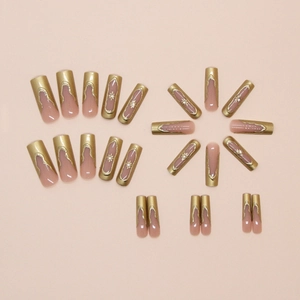 Close-up of French style press-on nails with golden edges and 3D floral accents