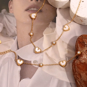 Close-up of 18K gold plated necklace with white shell hearts and round zircon crystals