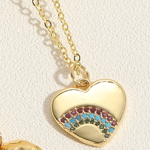 Macro shot of gold heart pendant necklace featuring vibrant rainbow zircon stones detail