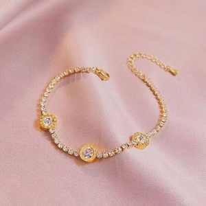 Elegant gold roman numeral bracelet with micro-pave crystals on pink satin background