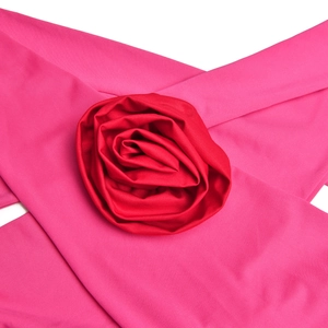 Detailed close-up of a large red 3D fabric flower on a pink backless halter dress