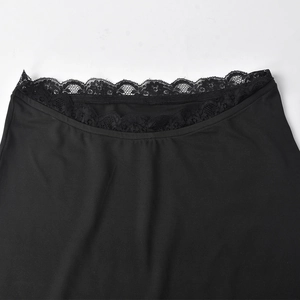 Close-up of black beach set featuring intricate floral lace trim and elastic knit fabric