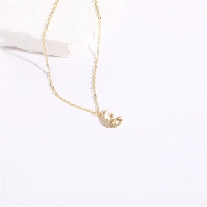 Detailed view of a 14K gold moon necklace featuring zircons and a small prince character