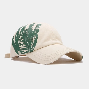 Distressed cream baseball cap featuring bold green Vibrate graffiti print on side