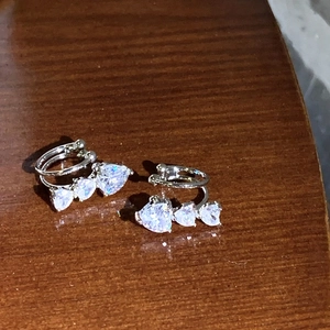 Primer plano detallado de pendientes de plata con circonitas en forma de corazón