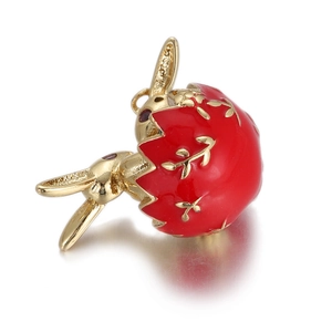 Detailed view of a gold bunny rabbit pendant with a red strawberry shell design