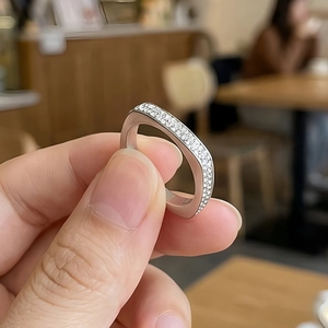 Détail macro d'une bague carrée argentée sertie de micro-zirconiums scintillants