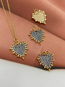 Macro shot of 18K gold plated heart pendant with cubic zirconia and mesh back details