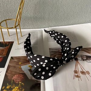 Detaillierte Nahaufnahme eines schwarzen Polka-Dot-Haarreifs mit schicker 3D-Schleife